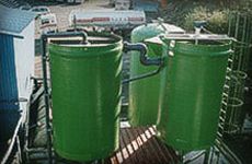 Un grupo de tanques verdes colocados sobre una plataforma de madera.