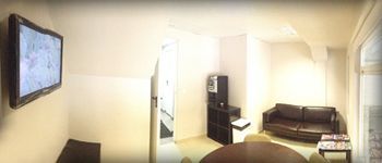 Una sala de estar con sofá, mesa y televisión.