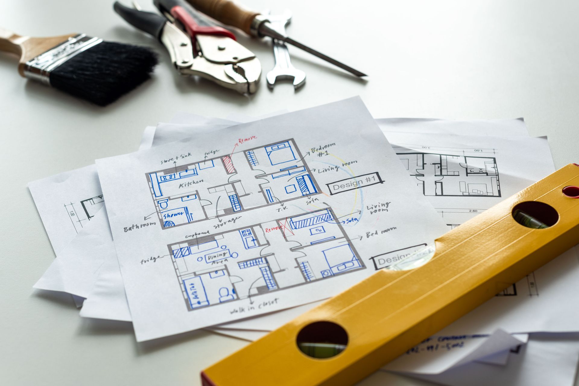 Plans et outils sur une table, avec un niveau à bulle jaune au premier plan