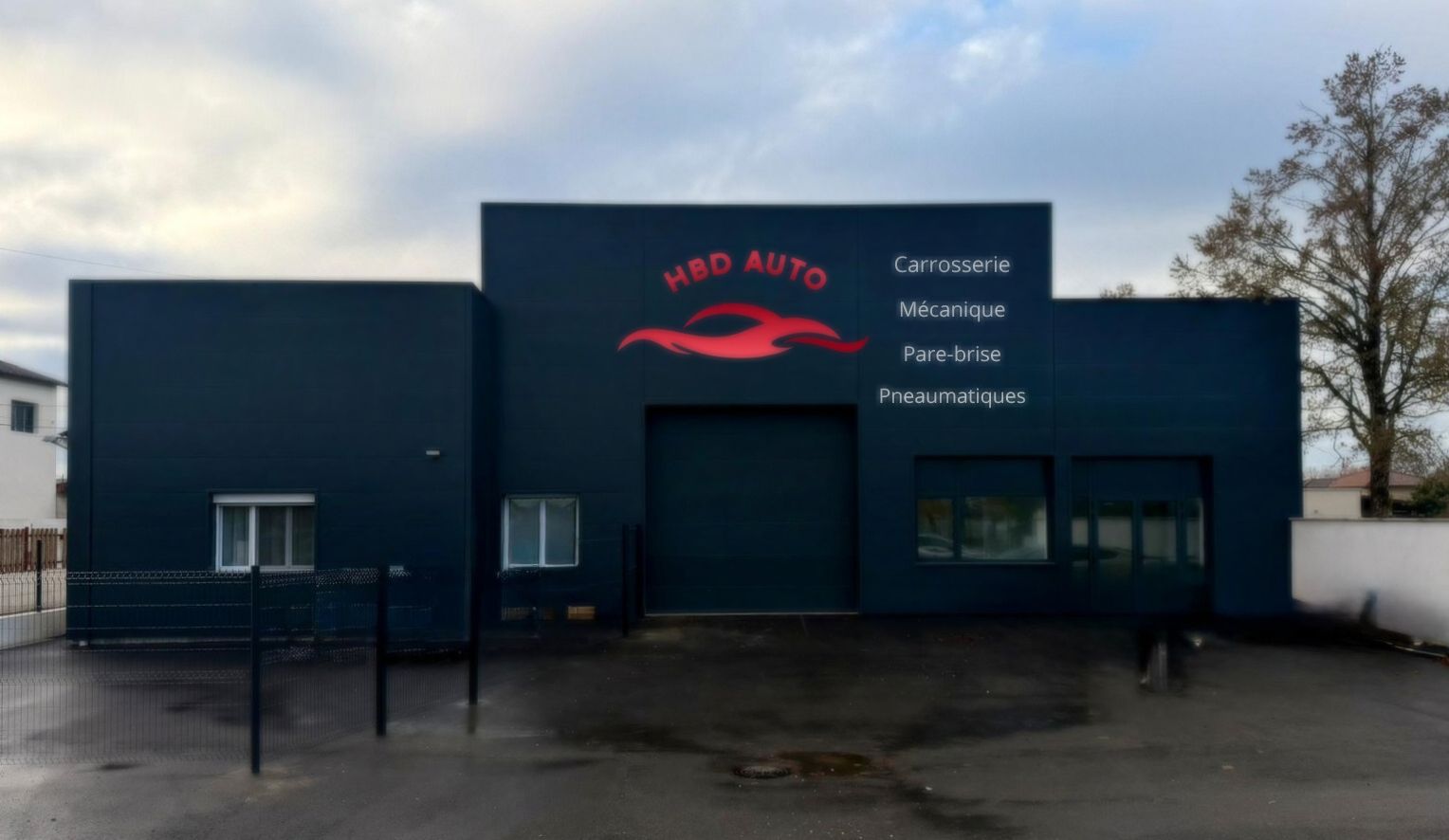 Deux mécaniciens travaillent sous une voiture soulevée par un pont élévateur dans un garage.