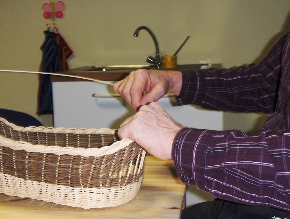 Älterer Mann flechtet einen Korb