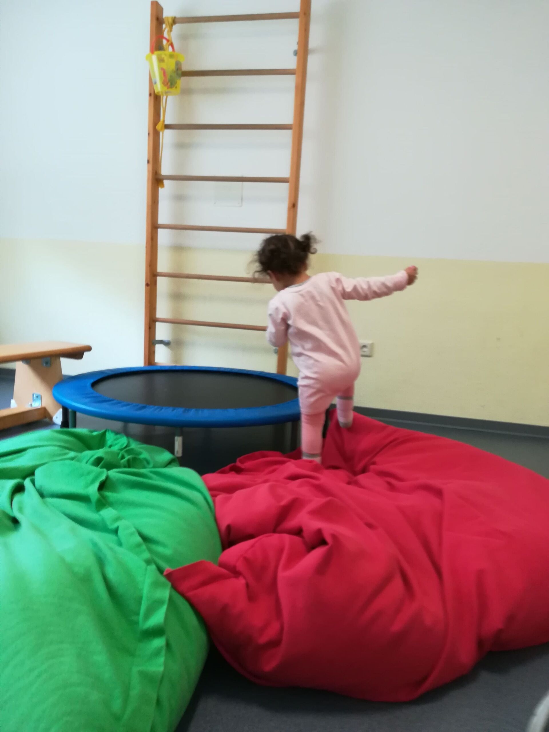 Kleines Mädchen spielt mit einem Trampolin