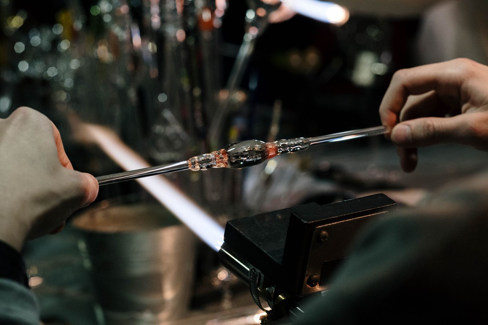 A craftsperson working with glass in a workshop