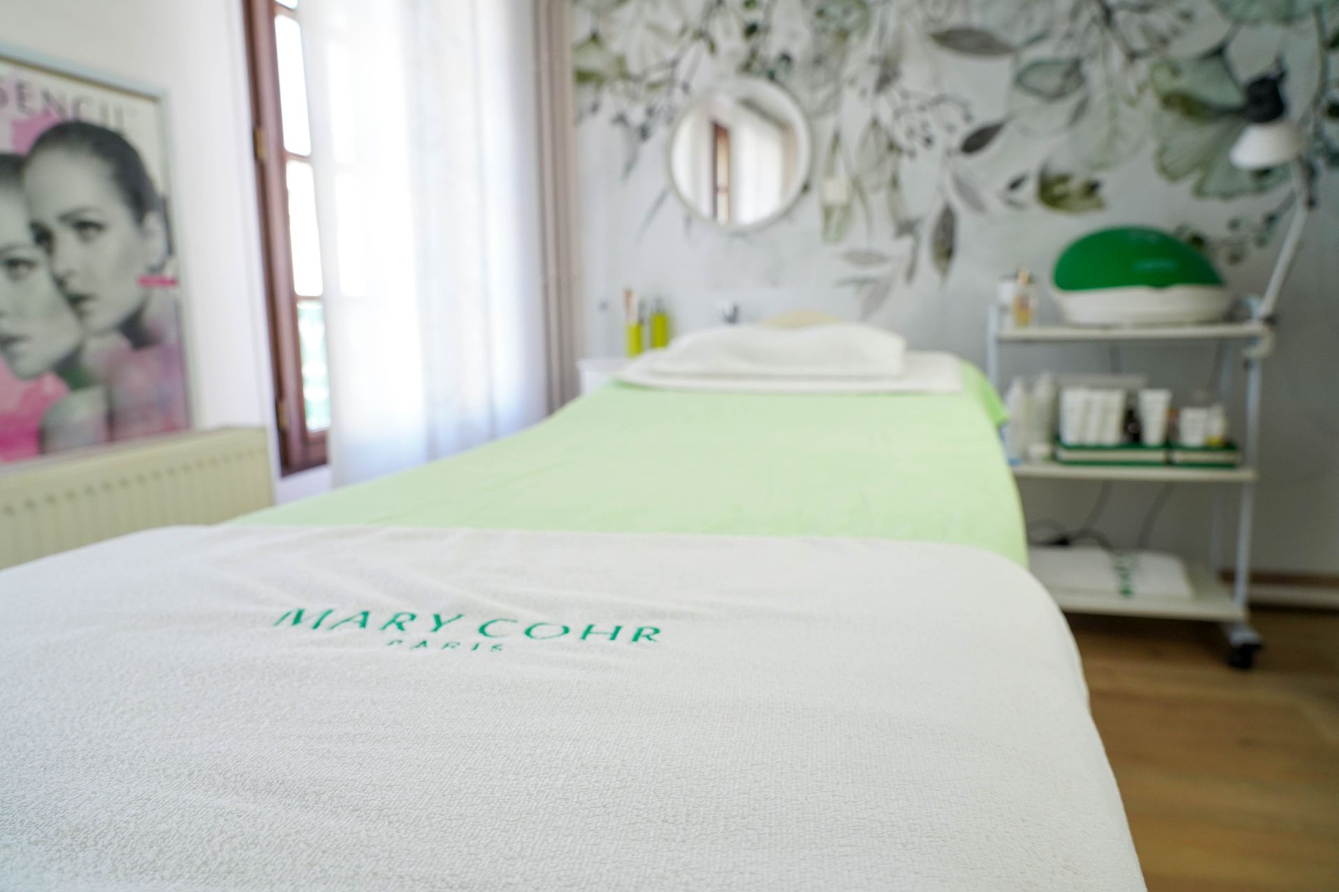 Femme recevant un soin du visage ; l'esthéticienne applique le masque avec un pinceau.