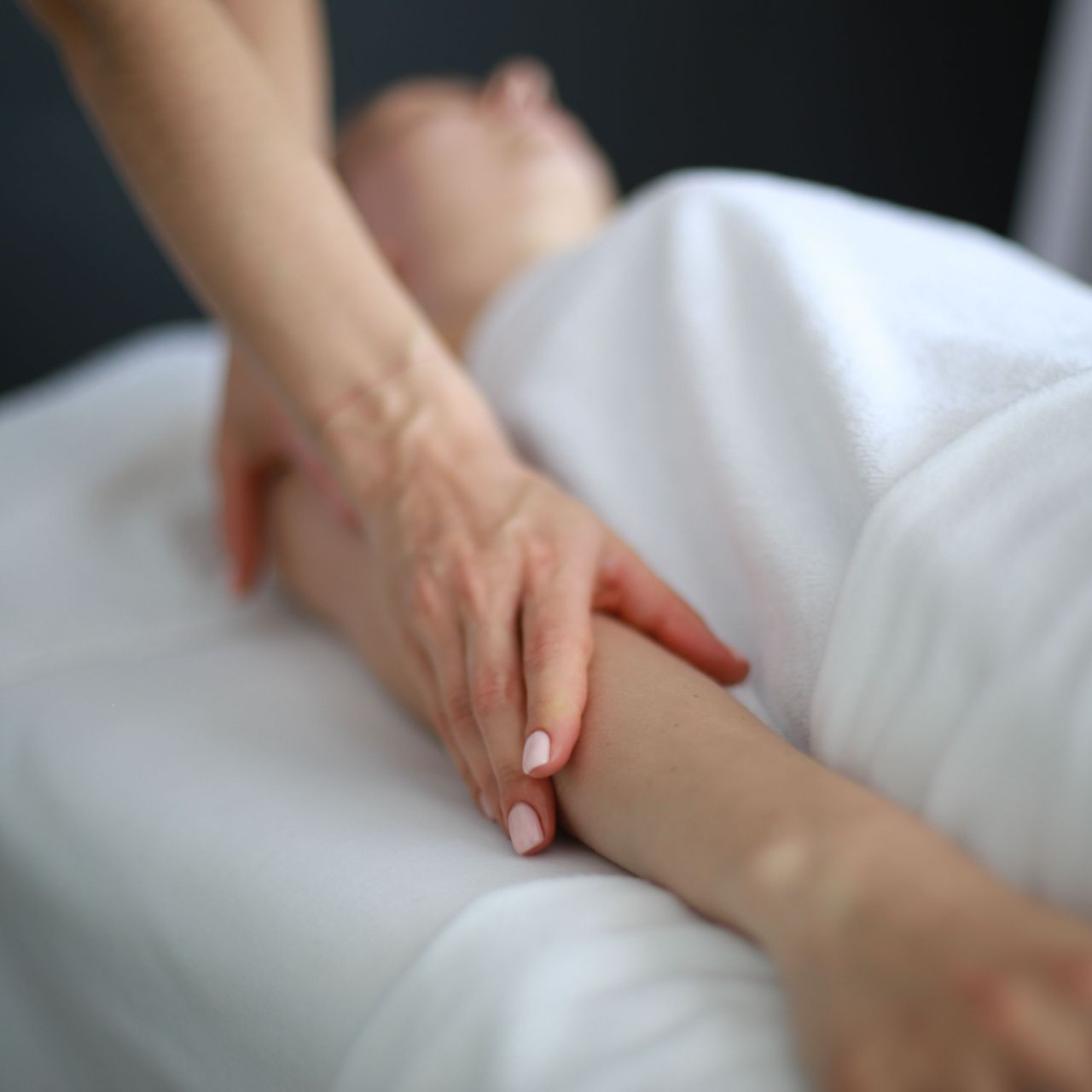 Massage du bras d'une personne allongée
