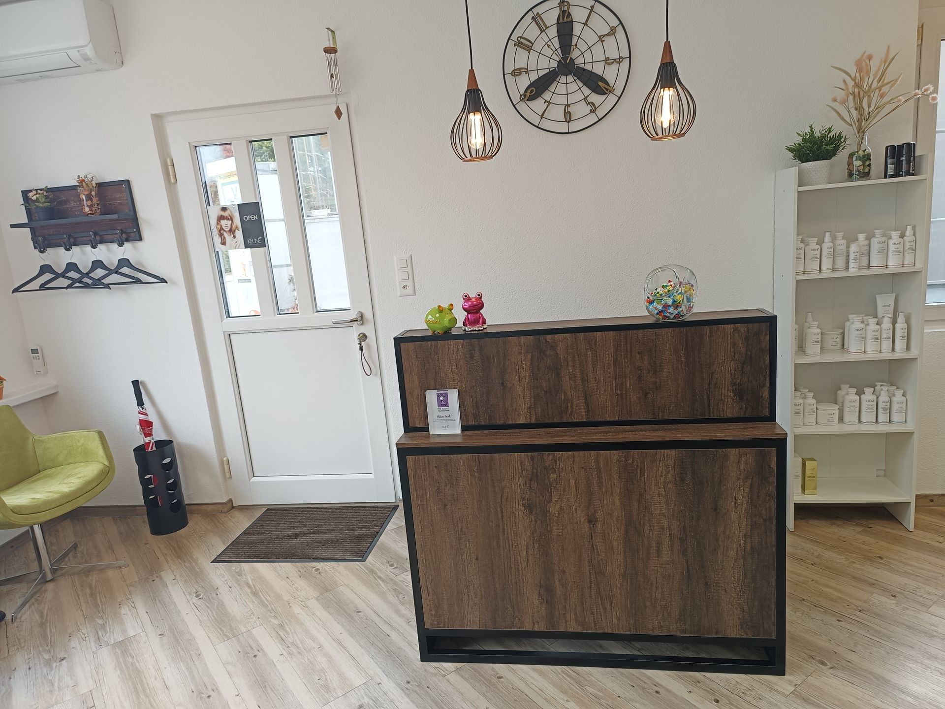 Ein Rezeptionstresen in einem Salon mit einer Uhr an der Wand.