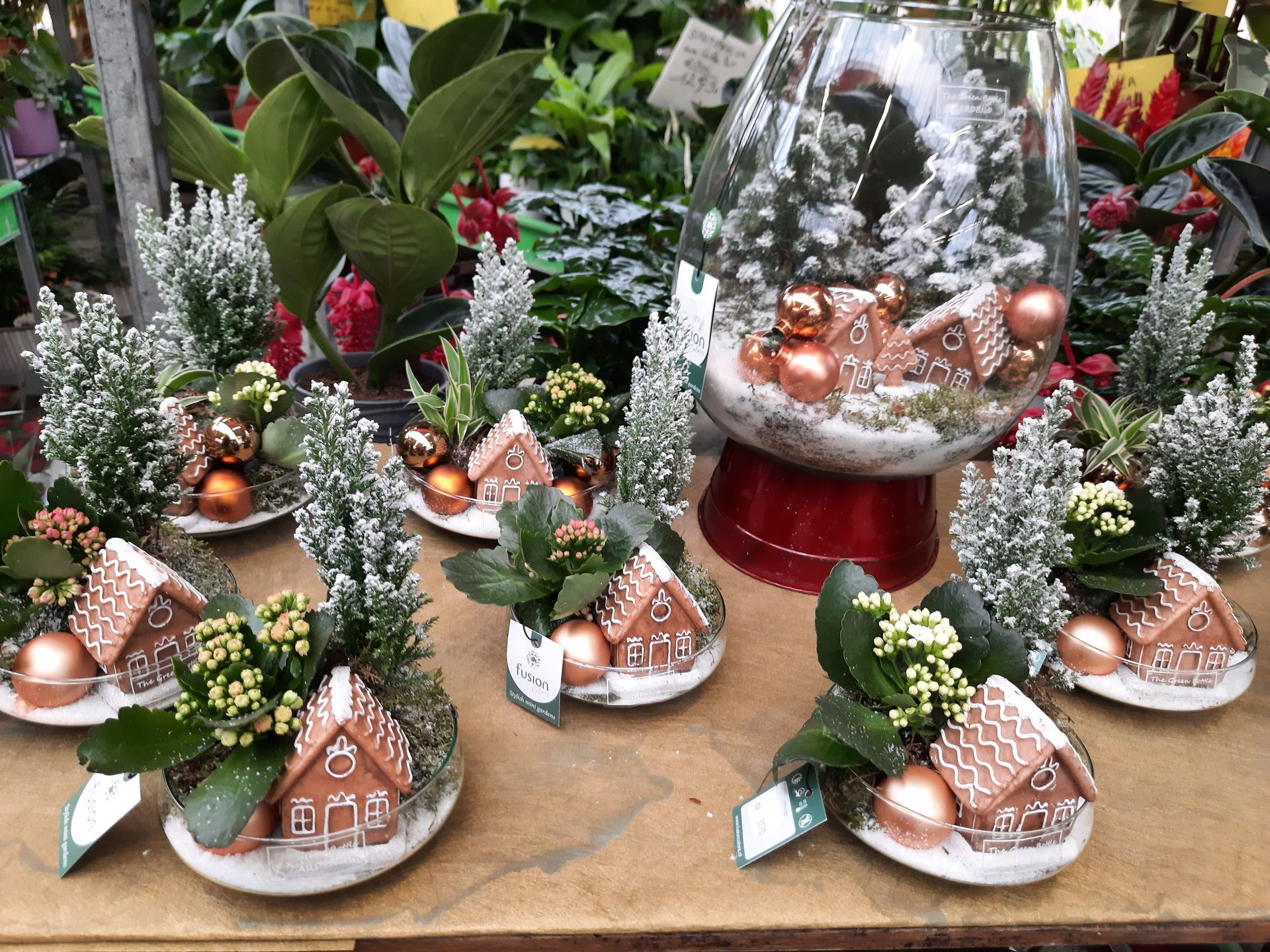 Miniatures décoratives de Noël avec sapins enneigés, maisons en pain d’épices et boules cuivrées