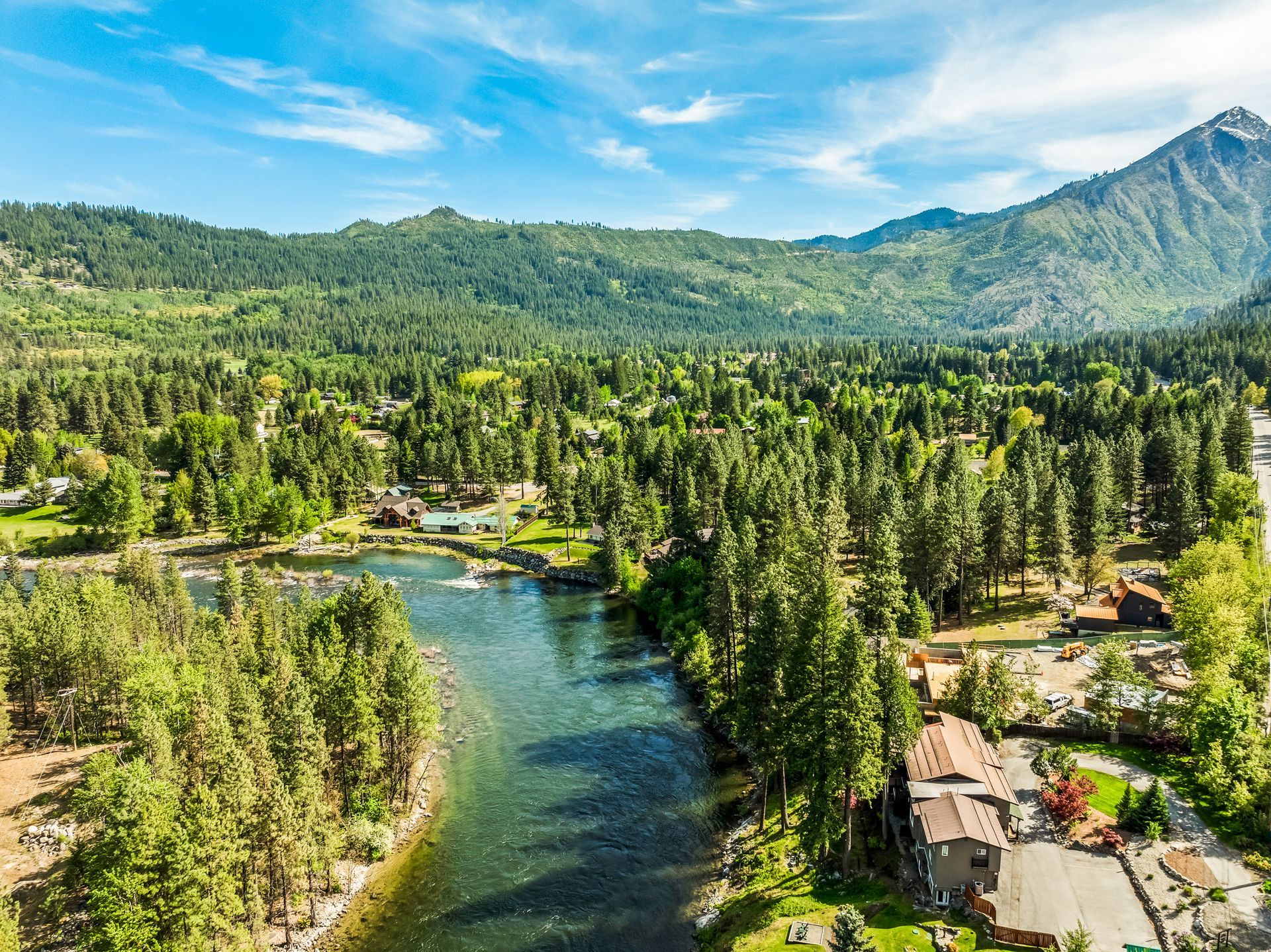 An aerial view of a river surrounded by trees and mountains.