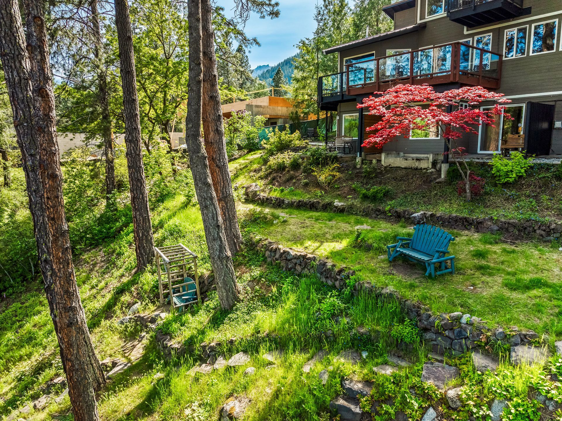 A house is sitting on top of a hill in the middle of a forest.