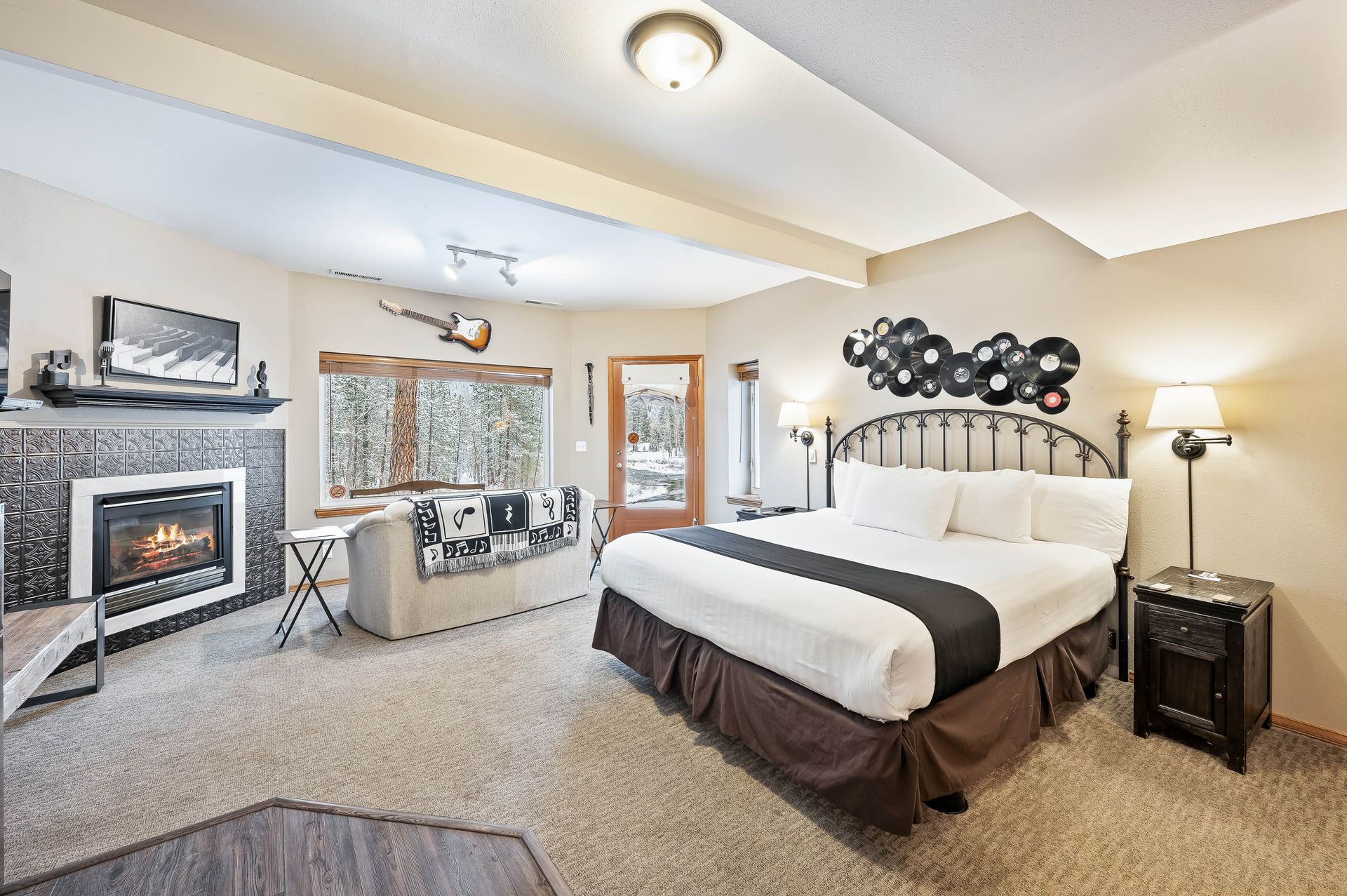 A hotel room with a king size bed and a fireplace.