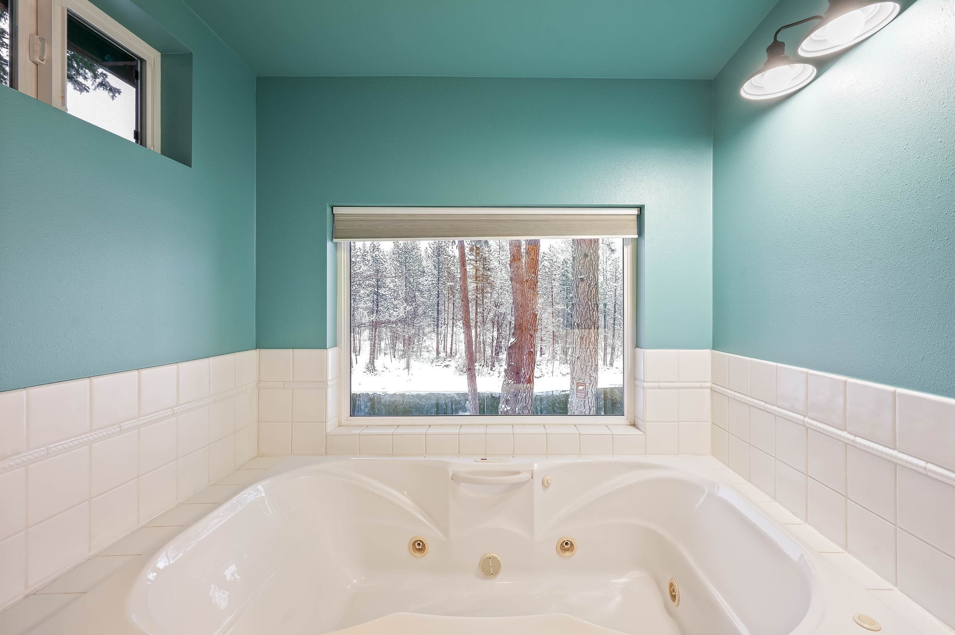 A bathroom with a jacuzzi tub and a window.