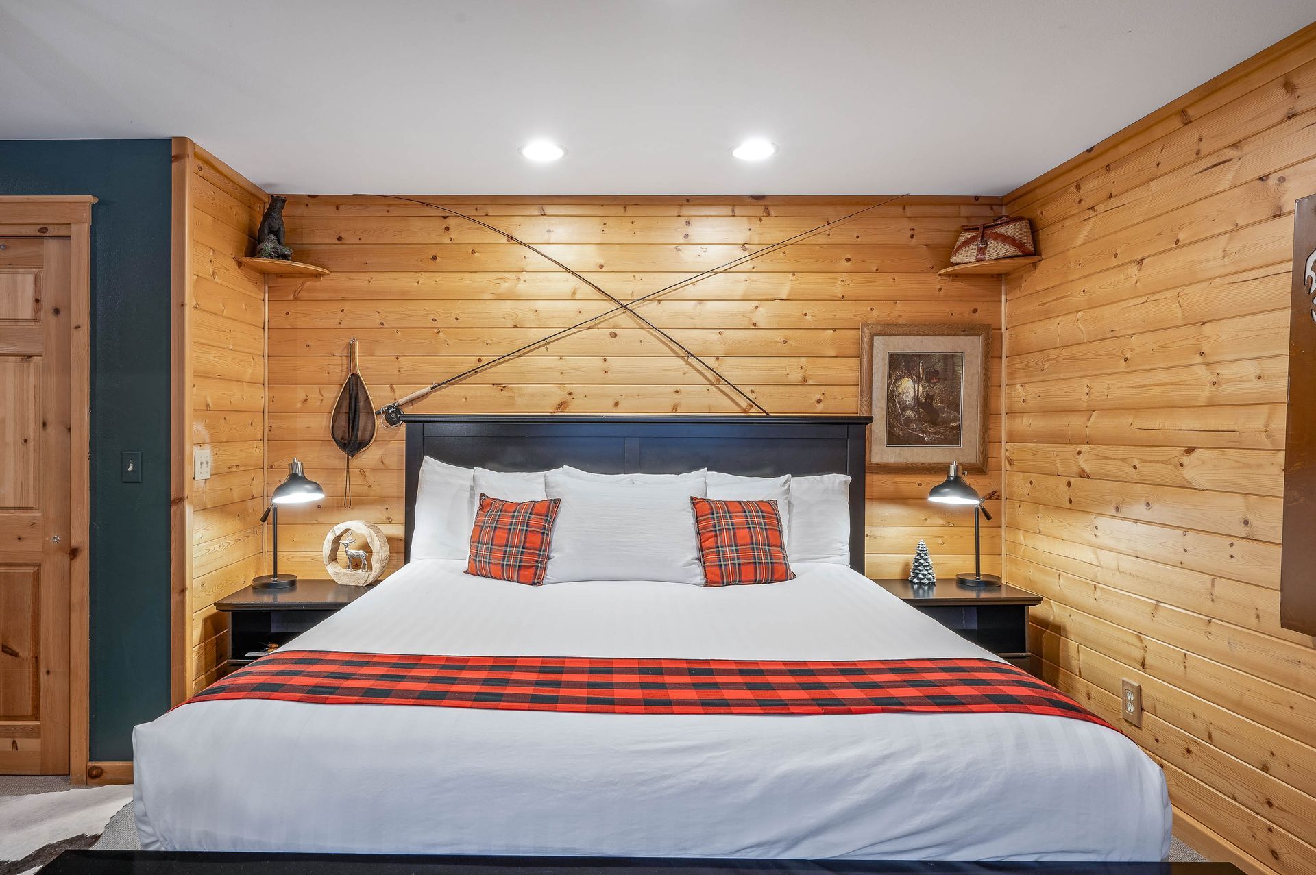 A bedroom with a king size bed and wooden walls.
