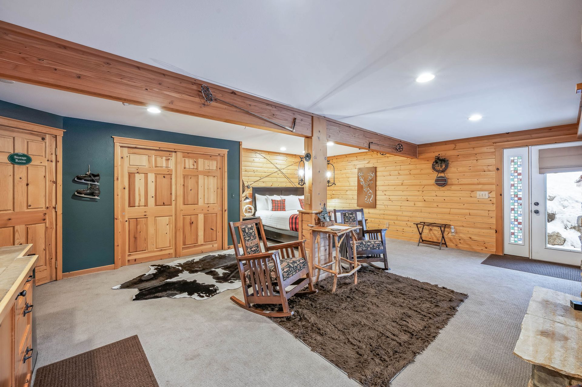 A living room in a log cabin with rocking chairs and a rug.