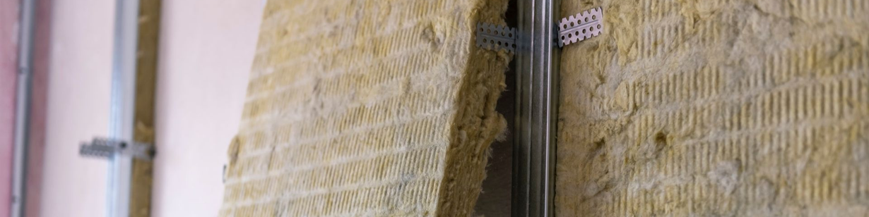 Des matériaux isolants sont posés le long d'un mur