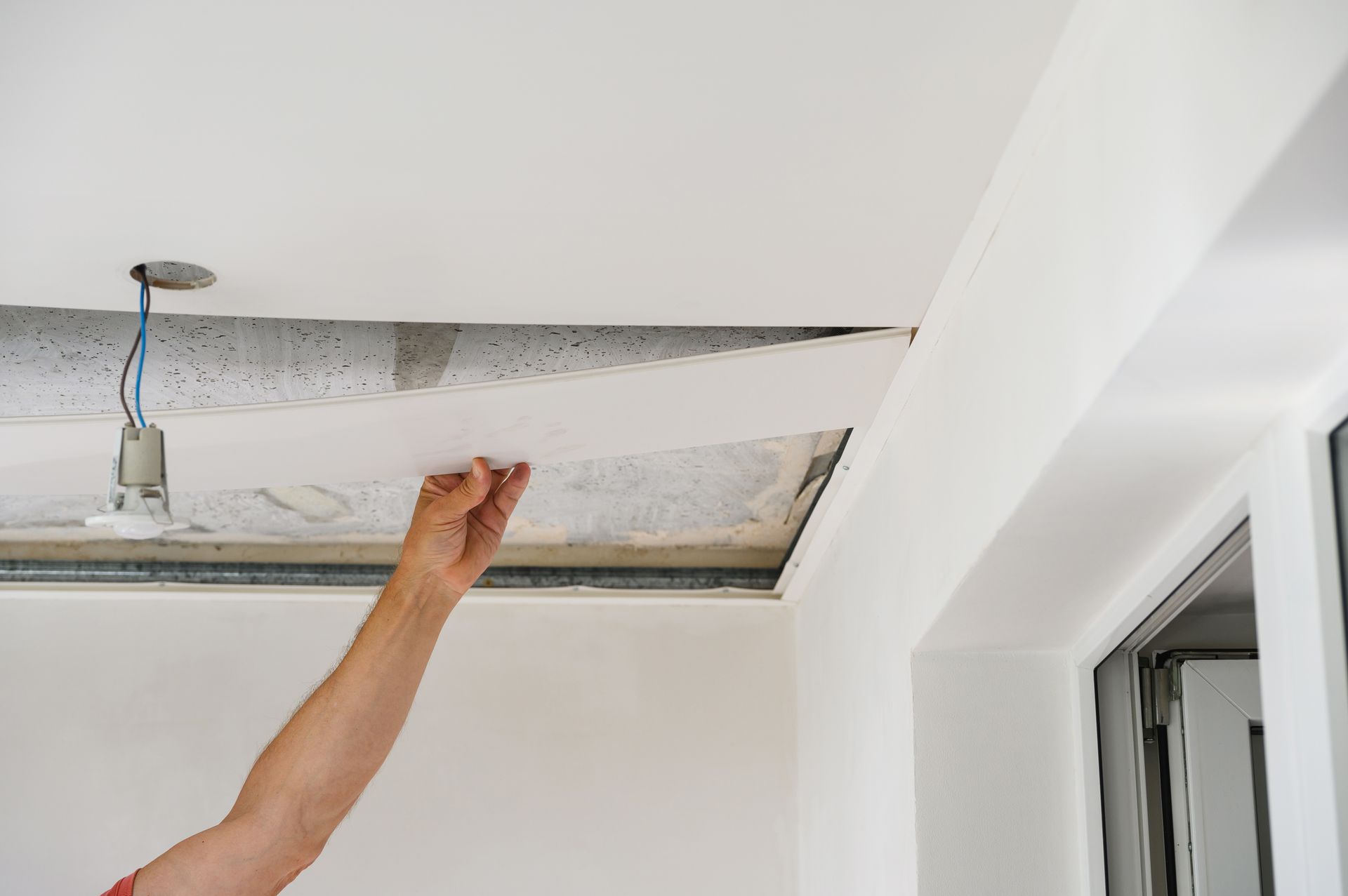Une personne pose une plaque sur un plafond
