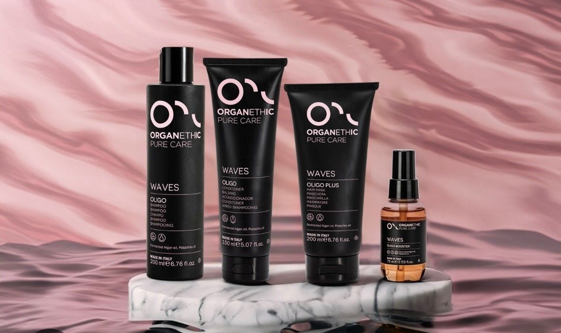 Schwarze Flaschen mit Bio-Haarpflegeprodukten von Pure Care stehen auf einem Holzregal neben einer grünen Pflanze.