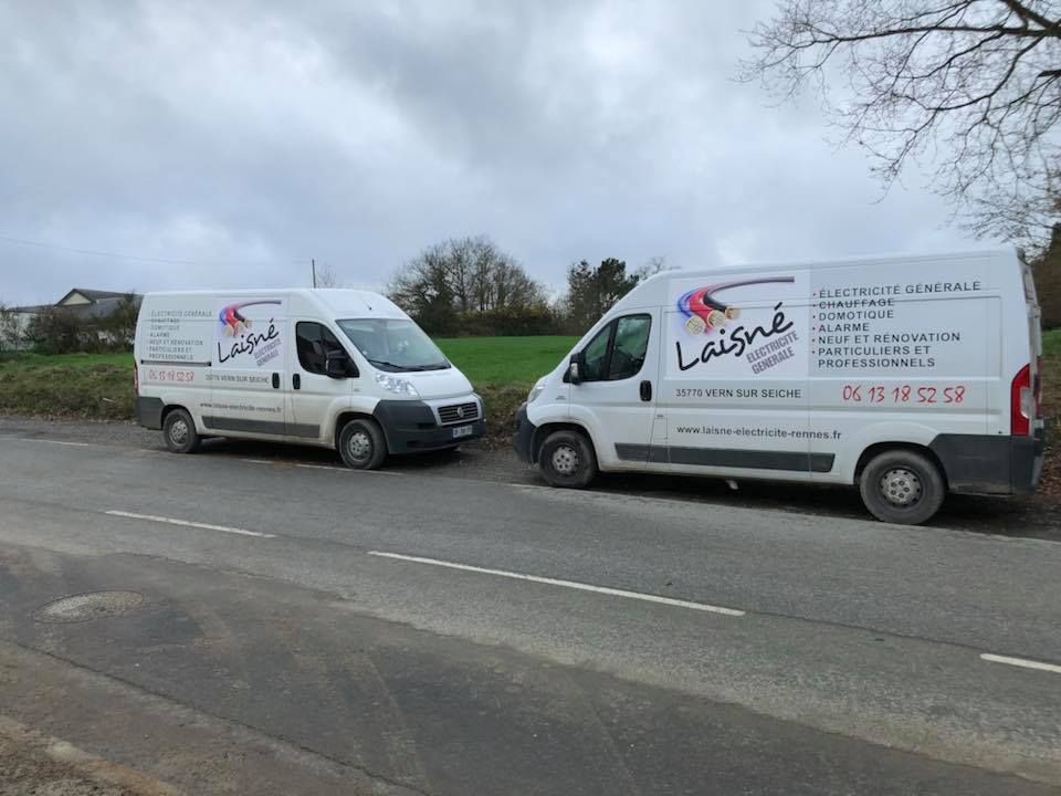 Deux camions de Laisné Électricité sur le bord de la route.