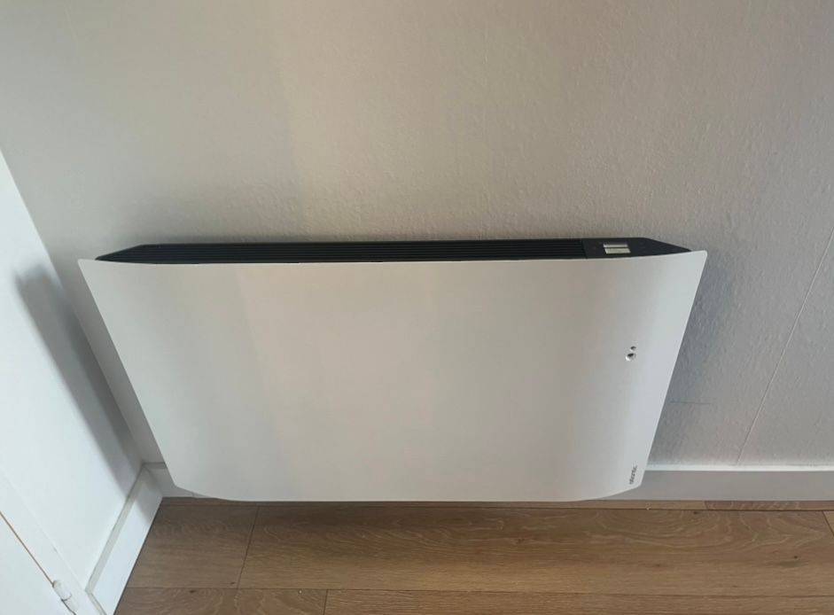 Radiateur électrique sur un mur blanc.