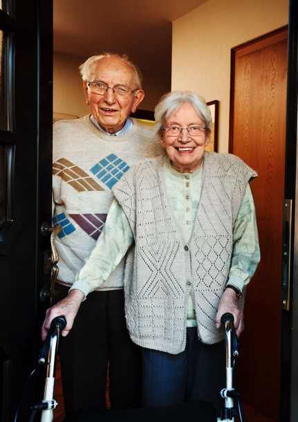 Medizinische Fachkraft in OP-Kleidung macht sich Notizen auf einem Klemmbrett, während sie mit einem Patienten spricht.