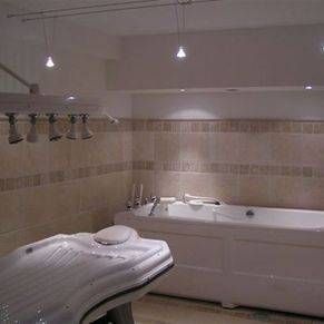 Une salle de bain avec baignoire et fauteuil massant.