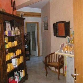 Une pièce avec une étagère remplie de nombreux produits cosmétiques et une chaise.