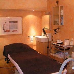 Une chambre avec un lit, un lavabo, un miroir et une lampe.