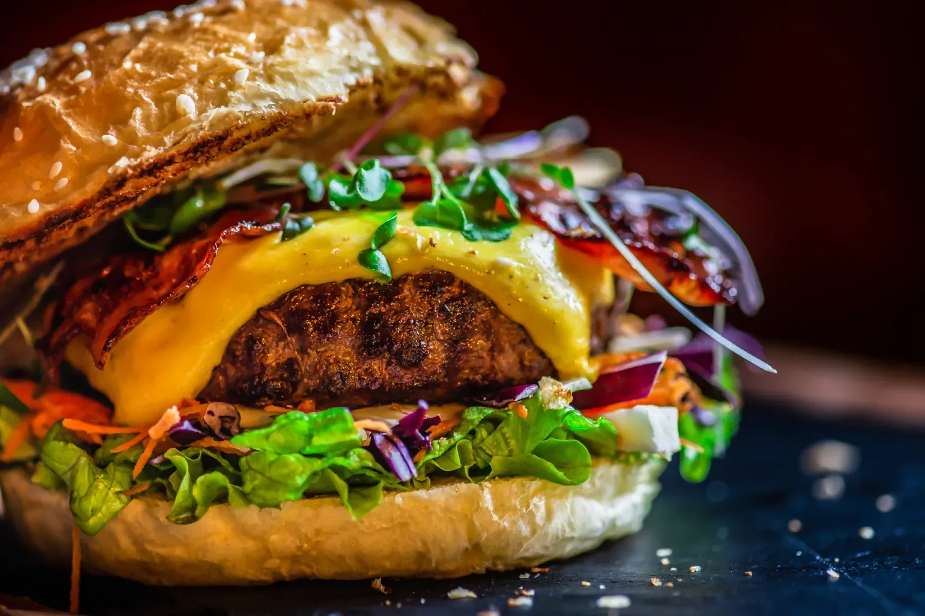 Dos patatas al horno en platos, cubiertas con diversos ingredientes y salsas.