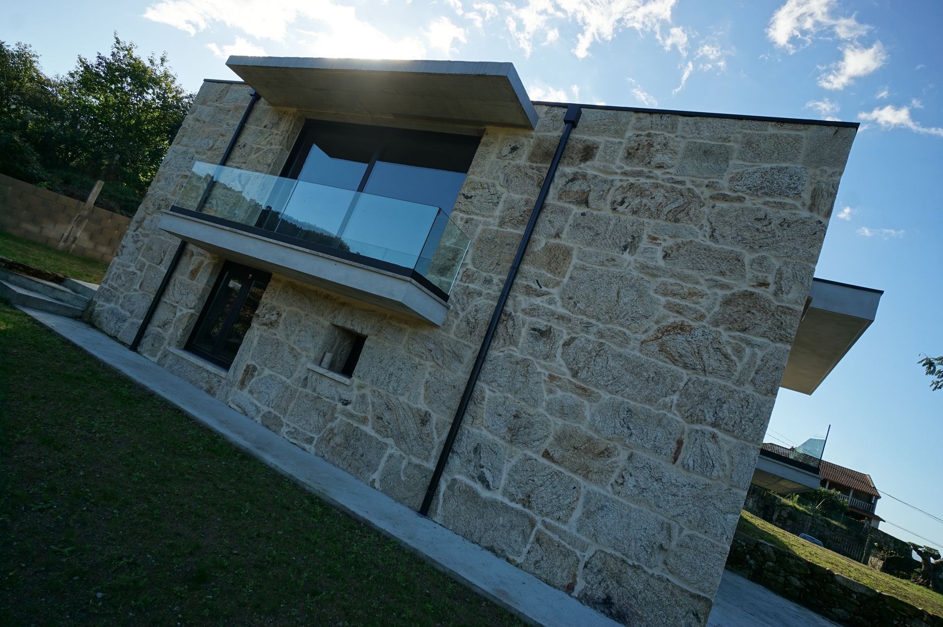 Un edificio de piedra con un árbol delante.