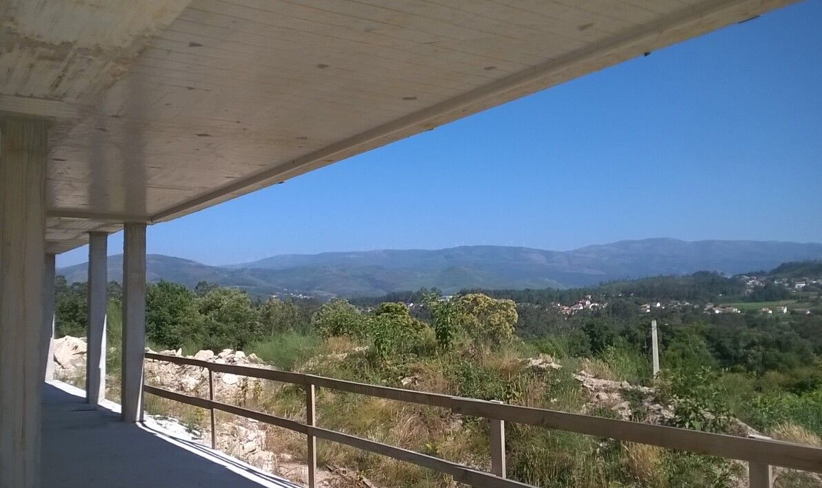 Un balcón con vista a las montañas y los árboles.