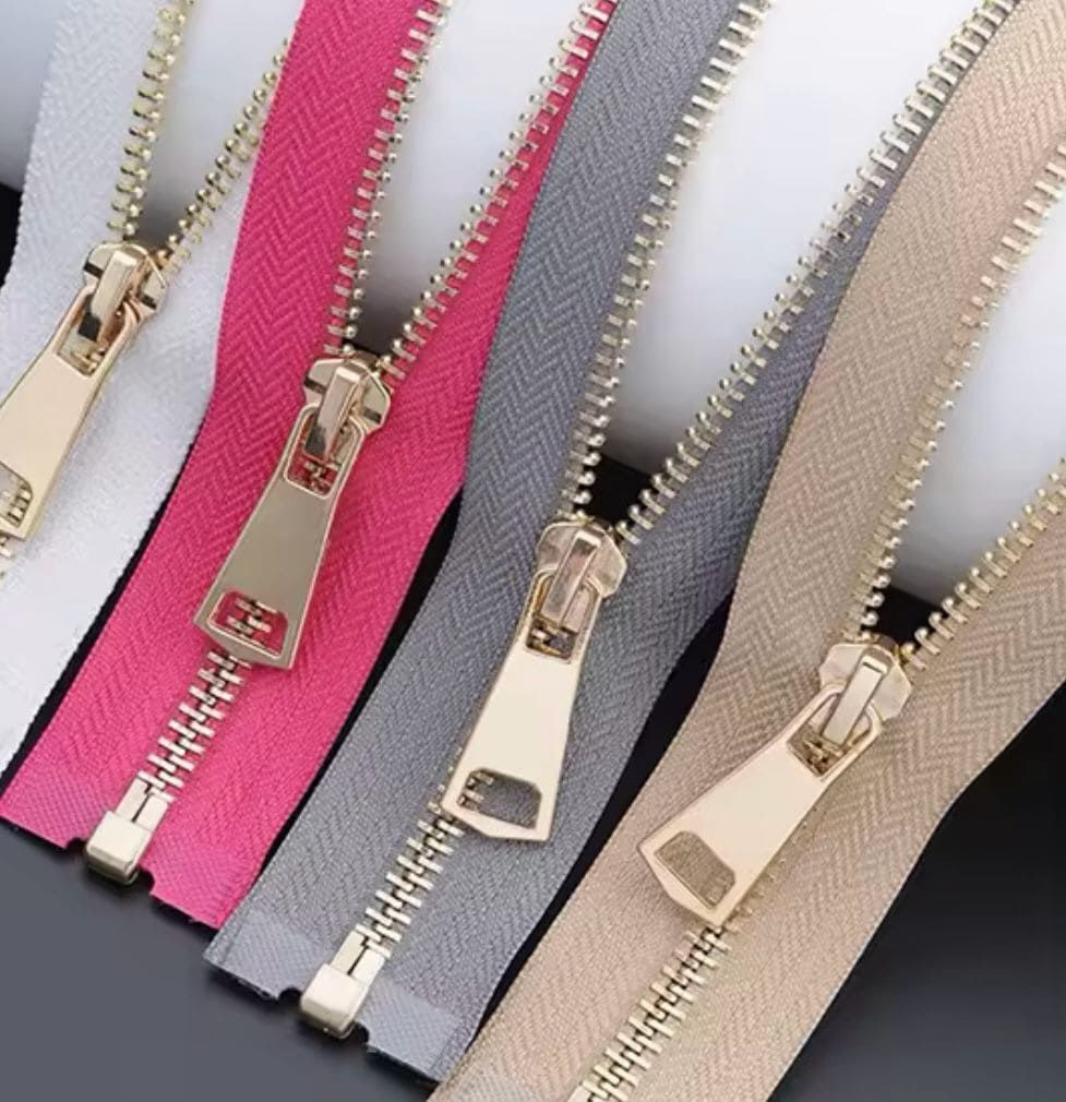 Cuatro cremalleras de diferentes colores están una al lado de la otra.