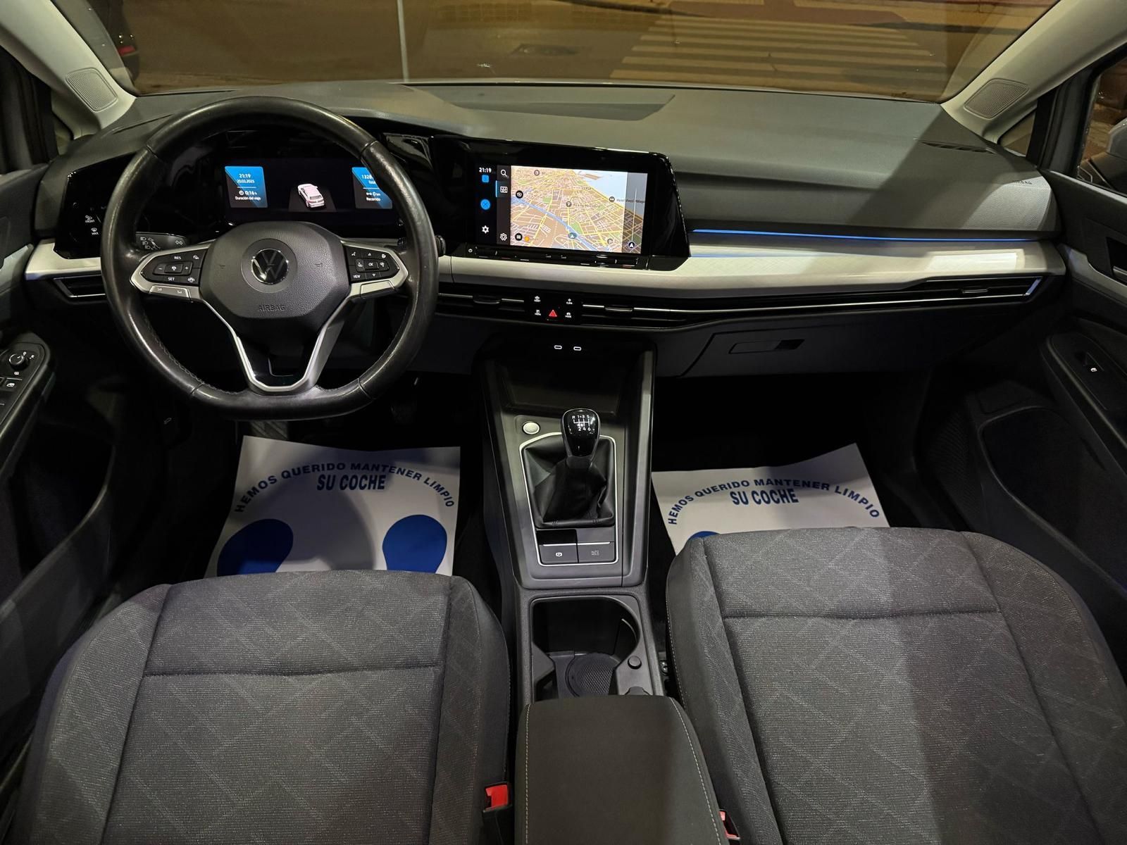 El interior de un coche con volante y asientos.