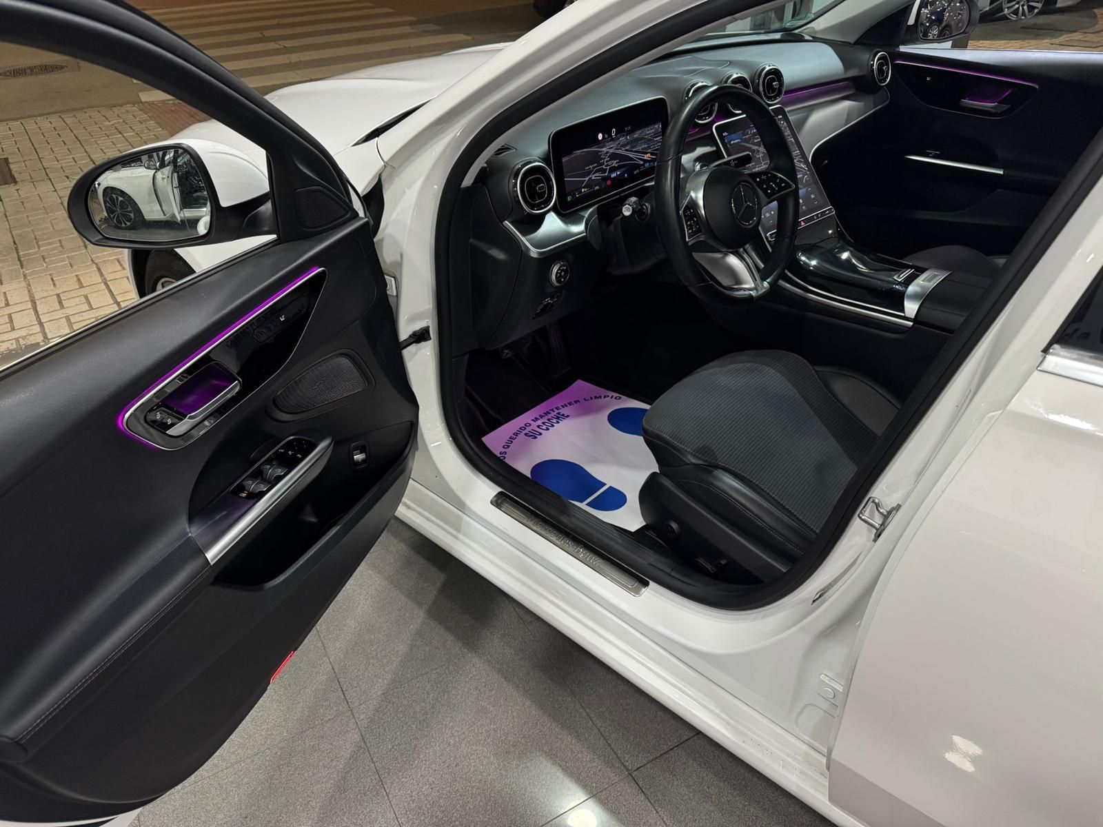 El interior de un coche blanco con la puerta abierta.