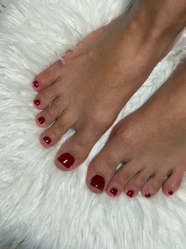 Manos con uñas pintadas de colores brillantes y bien cuidadas, mostradas sobre un fondo blanco.