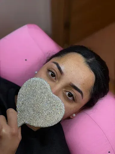 Manos con uñas pintadas de colores brillantes y bien cuidadas, mostradas sobre un fondo blanco.