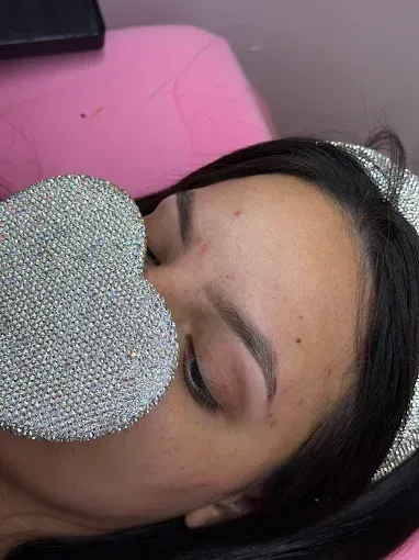Manos con uñas pintadas de colores brillantes y bien cuidadas, mostradas sobre un fondo blanco.