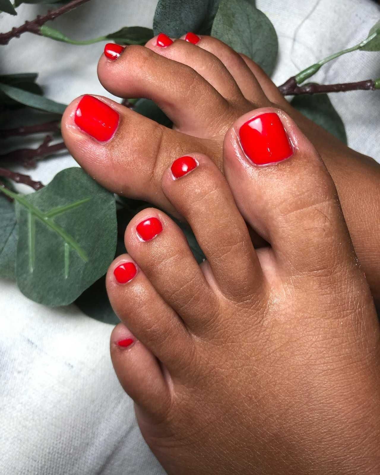 Manos con uñas pintadas de colores brillantes y bien cuidadas, mostradas sobre un fondo blanco.