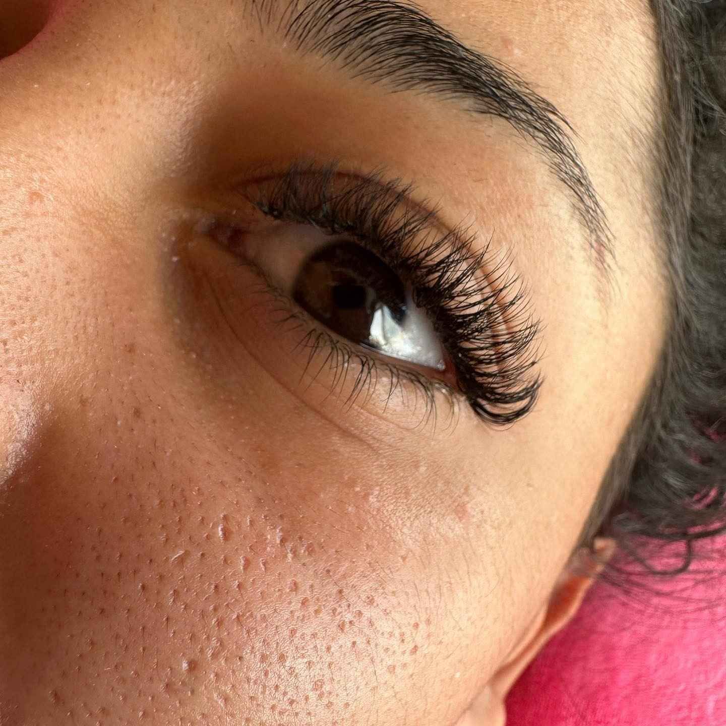 Manos con uñas pintadas de colores brillantes y bien cuidadas, mostradas sobre un fondo blanco.
