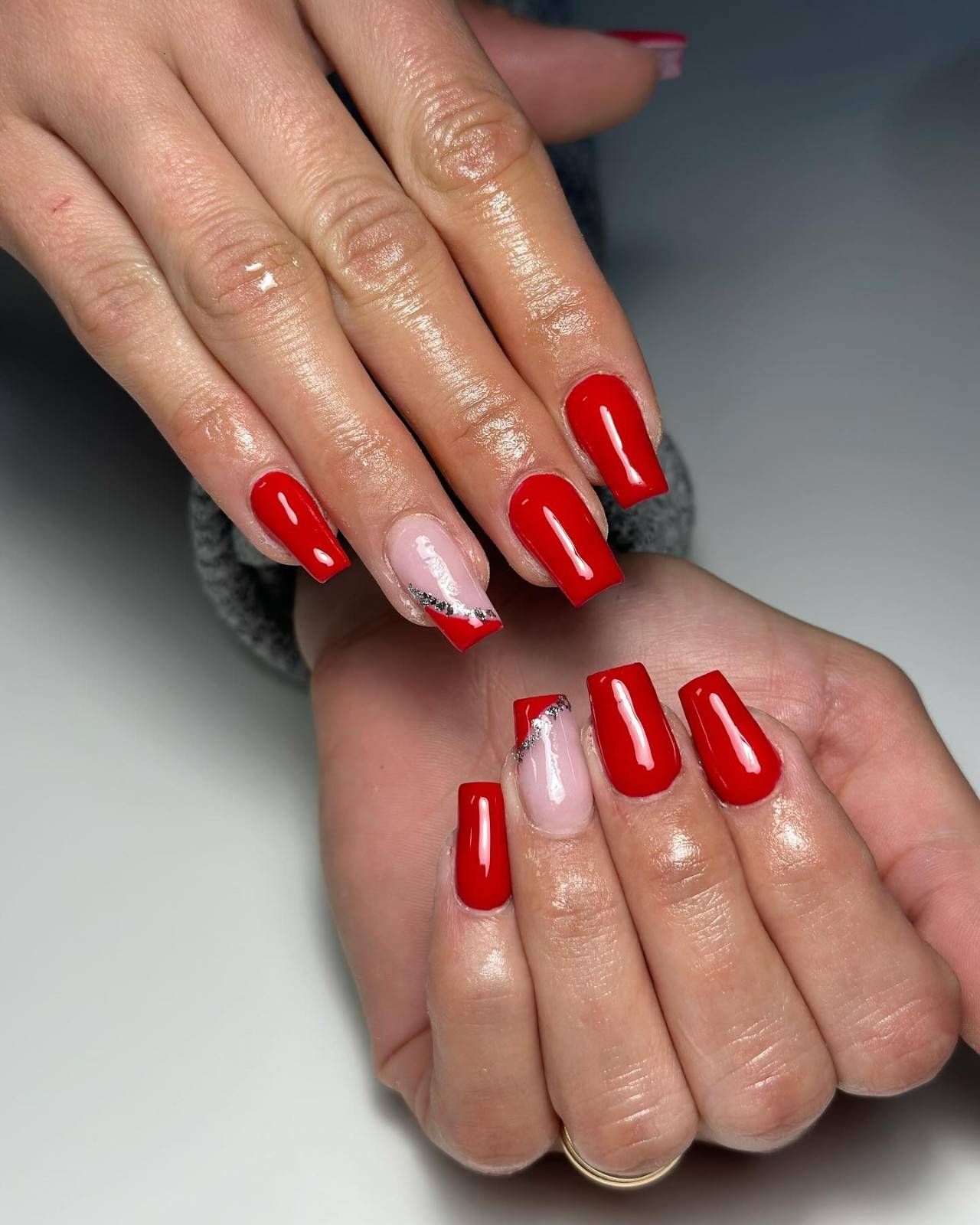Manos con uñas pintadas de colores brillantes y bien cuidadas, mostradas sobre un fondo blanco.