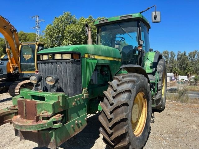 Un tractor John Deere verde está estacionado en un campo