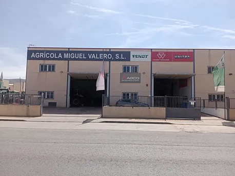 Un gran edificio con un cartel que dice Agrícola Miguel Valero SL
