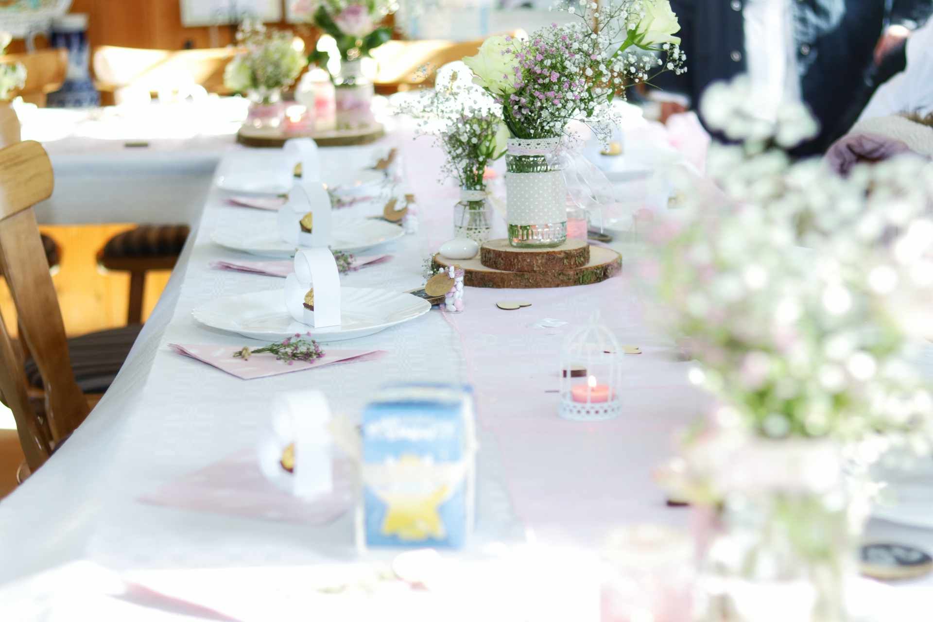Decorated table set for an elegant outdoor event with floral centerpieces and place settings