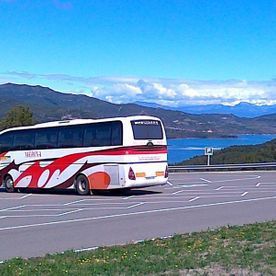 Un autobús rojo y blanco está estacionado al costado de la carretera.