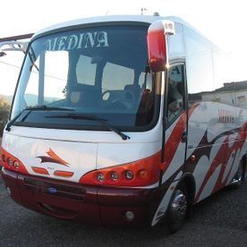 Un autobús de la medina está estacionado al costado de la carretera.