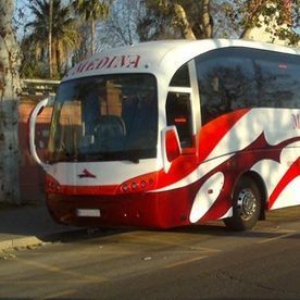 Un autobús rojo y blanco está estacionado al costado de la carretera.