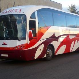 Un autobús rojo y blanco está estacionado al costado de la carretera.