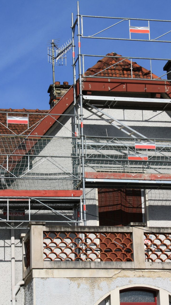Un échafaudage contre la façade d'une maison ancienne.