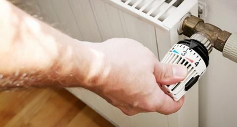 Una persona está ajustando un termostato en un radiador.