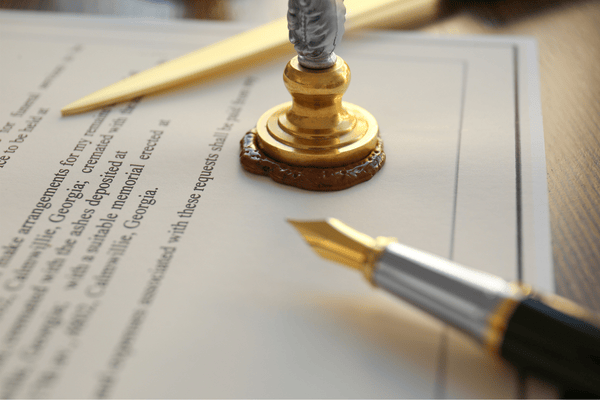 Documento legal con sello de lacre y pluma fuente.