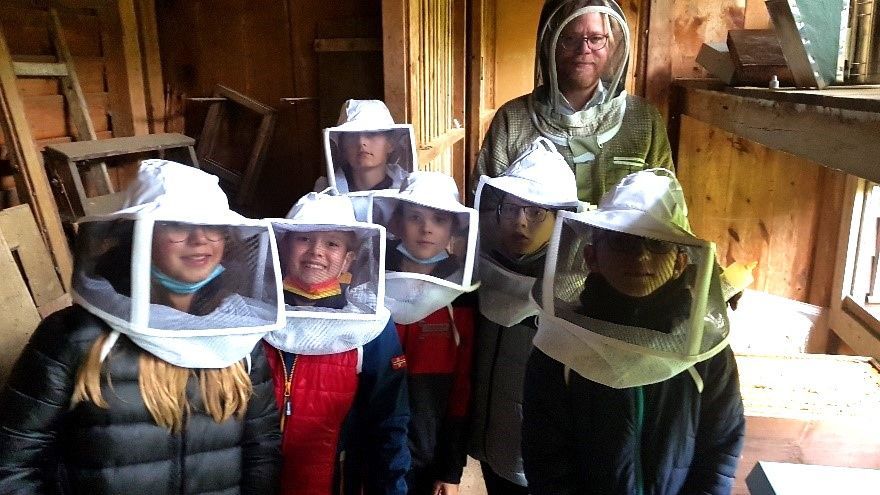 Kinder besuchen im Wahlkurs Biene einen Imker