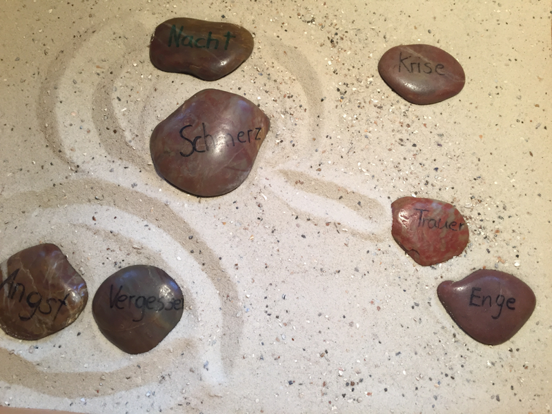 Sandbild mit Steinen